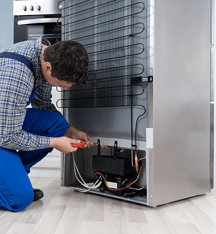 Technician repairing a refrigerator